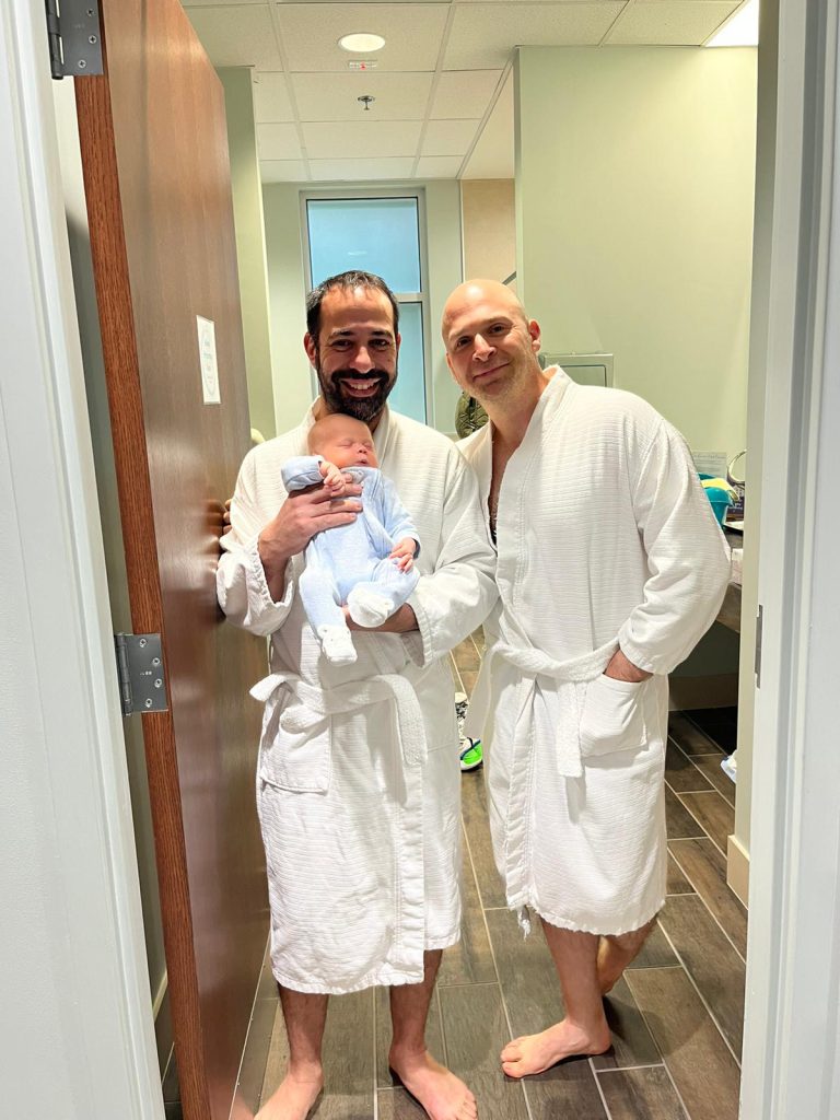 Two men holding a baby at Metro Atlanta Community Mikvah